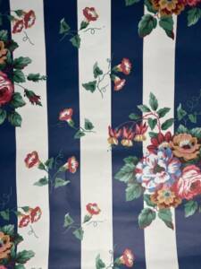 Vintage wallpaper with navy and cream stripes, trailing morning glory vines, and pink floral bouquets